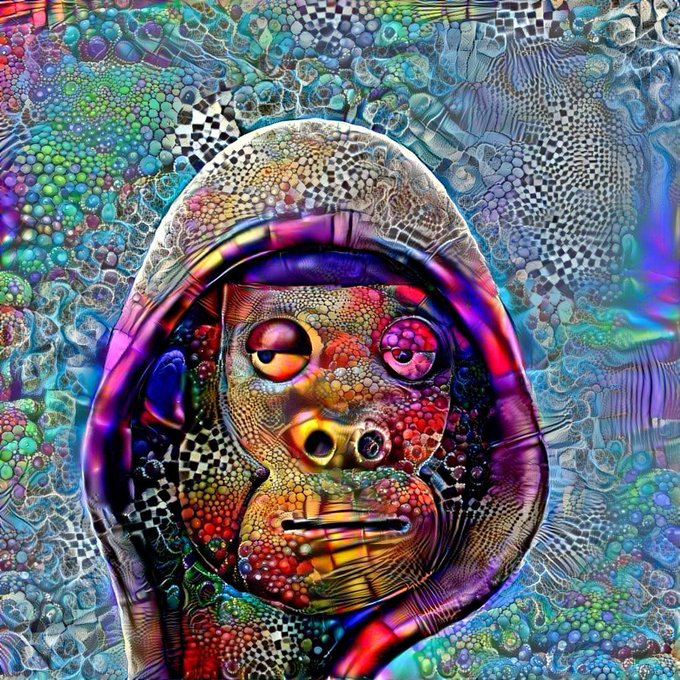 A vibrant, psychedelic digital artwork depicting a hooded face rendered in intensely colorful, intricate mosaic-like patterns with multicolored dots and textures surrounding the central figure.