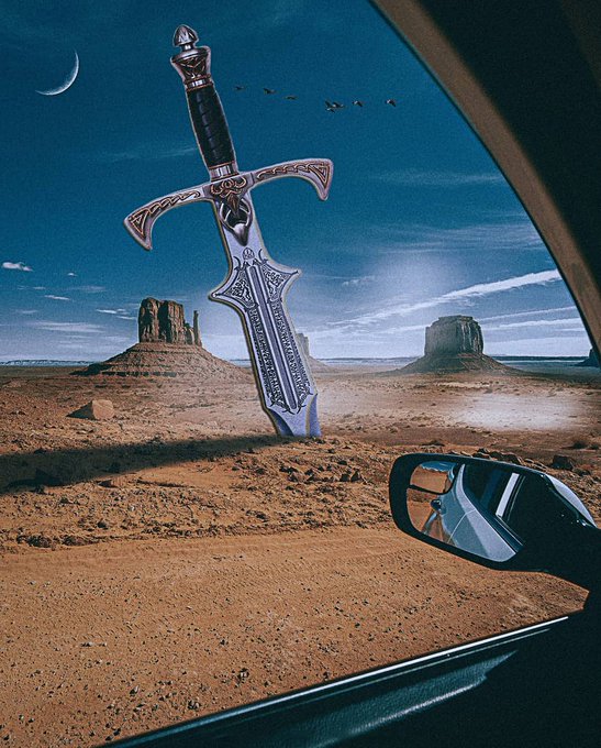 A surreal composite image taken from inside a car shows a giant ornate sword planted in the desert ground like Monument Valley, viewed past the side mirror under a sky with a crescent moon.