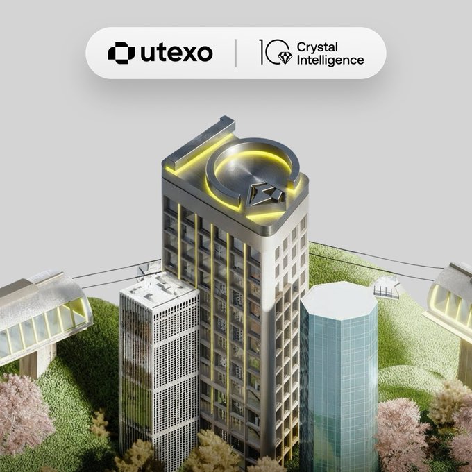 The image showcases the Utexo and Crystal Intelligence logos above a 3D cityscape model with a prominent building featuring the "IO" logo illuminated in yellow on top. This visual represents the partnership between Utexo and Crystal Intelligence, complementing the announcement of real-time risk monitoring capabilities for clients.