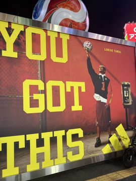 An outdoor advertisement featuring a football player in a red jersey raising a ball, with large yellow text reading 'YOU GOT THIS'.