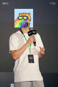 A person in a white t-shirt holds a microphone on a stage at a BKX event, with their face obscured by a cartoon bear sticker wearing sunglasses.