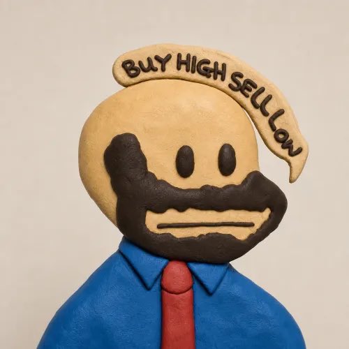 A clay sculpture of a bearded man in a blue shirt and red tie, with the phrase 'BUY HIGH SELL LOW' written across the top of his head.