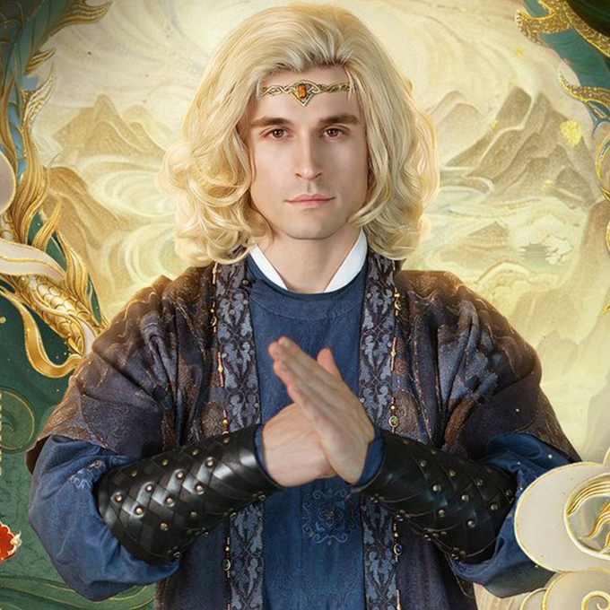 A blonde figure in ornate robes with a golden headband and studded leather bracers stands with hands pressed together in a contemplative gesture against a mountainous backdrop. The post's reference to "a coin with a Chinese ticker" ties into the fantasy aesthetic and mysterious, enigmatic pose, suggesting the feeling of cautious intrigue or uncertainty when investing in an unfamiliar cryptocurrency.