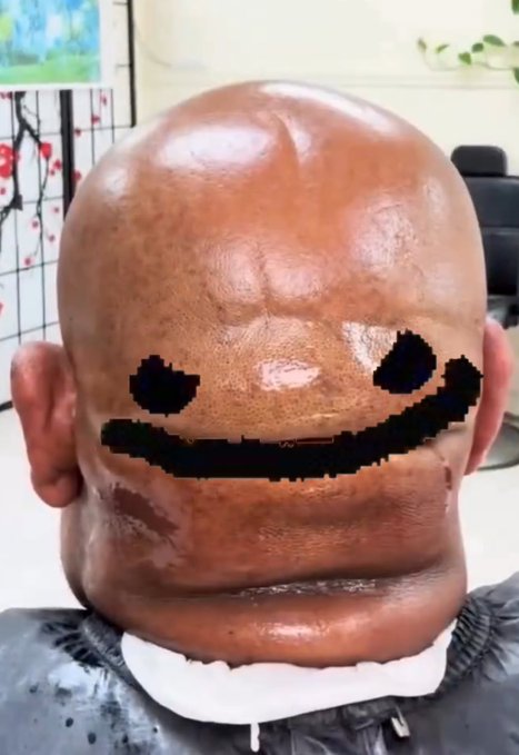 A hyper-realistic sculpture of a head with a pixelated smiley face design carved into it, sitting on a white base.
