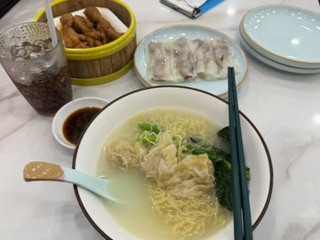 The image shows a dining table with various dishes, including bowls of food such as soup or noodles, plates of food like dumplings, and drinks like soda. The table also has chopsticks placed next to some of the dishes. There is a cup on the table as well. The post appears to be about Bitcoin wallets and cryptocurrency, possibly suggesting that someone is sharing their experience with digital currency or discussing its potential uses in everyday life.