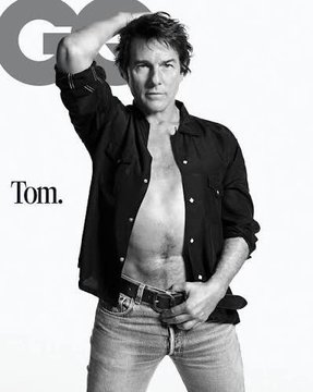 Black-and-white GQ magazine cover featuring a shirtless man in an open black button-down and jeans, captioned 'Tom.'