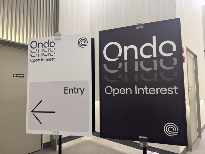 Two branded "Ondo Open Interest" signs stand at an entryway in Singapore, welcoming attendees to the event. The display features the Ondo logo alongside an arrow directing guests inside, marking the start of the Ondo Private Markets gathering.