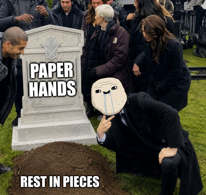 A meme showing people gathered around a tombstone labeled 'PAPER HANDS' with 'REST IN PIECES' caption, featuring a crying wojak-style face in the foreground, mocking traders who sold at a loss.