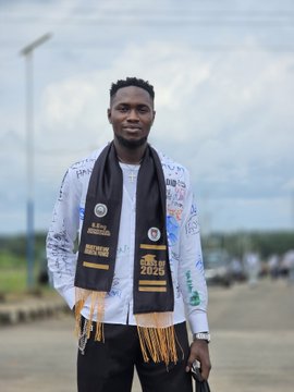 A young man stands proudly outdoors wearing a commemorative scarf marked "2023," celebrating his Bachelor of Science (BSC) achievement, embodying the caption "BSC BAGGED... GOD DID" as a testament to his academic accomplishment.