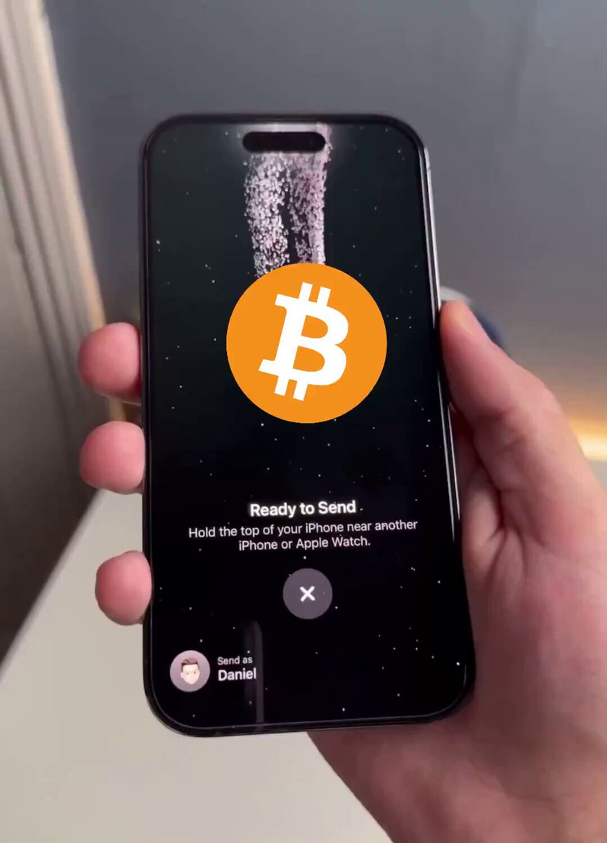 The image shows a person holding up their phone displaying an advertisement for Bitcoin, with the Bitcoin symbol prominently displayed. The text on the screen reads "Ready to send Bitcoins", indicating that someone is about to send Bitcoins or has recently sent them. This advertisement seems to be related to Apple's announcement of a new product release, as suggested by the phrase "BUY BITCOIN BEFORE APPLE ANNOUNCES THIS".