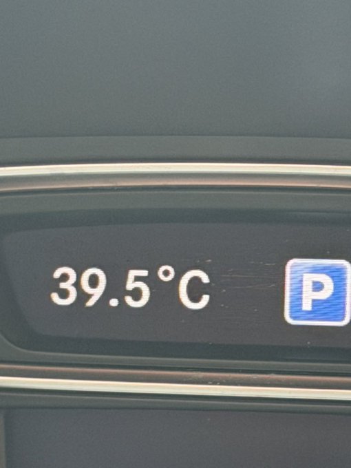 A close-up of a digital car dashboard display showing a temperature reading of 39.5°C next to a 'P' indicator for Park.