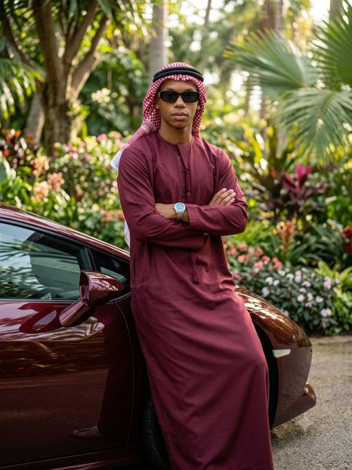 A man in a maroon thobe, white-and-red checkered keffiyeh, and sunglasses leans against a sleek burgundy sports car in a lush garden setting, projecting a confident, stylish vibe fitting the upbeat "GM and happy Thursday" greeting.