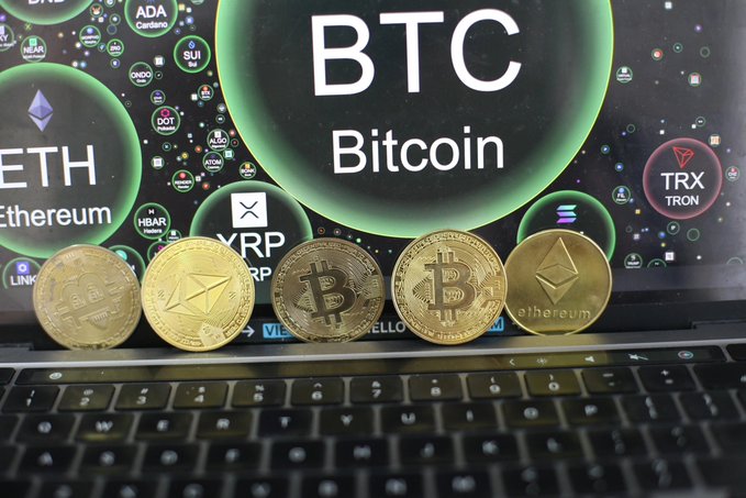 Physical representations of Bitcoin, Ethereum, and XRP rest on a laptop keyboard, against a screen displaying crypto names and tickers such as “BTC Bitcoin,” “ETH Ethereum,” and “TRX TRON.” The scene reinforces the post’s message of low exchange inflows and limited selling pressure from large Bitcoin “whale” wallets.
