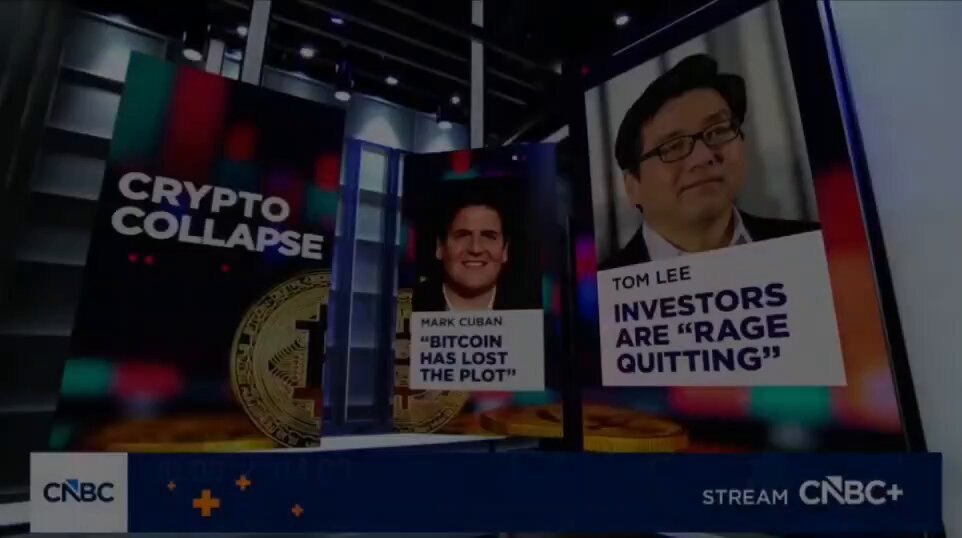 The image features a poster displaying two men, one wearing a suit and tie, with the other sporting sunglasses and a mustache, both holding up signs that say "Crypto Collapse", "Investors are angry!", and "Bits are going to be lost!". The background of the poster is dark. A caption at the bottom of the image reads: "Just in: $344 Million ProCap Finance CEO Anthony Pompliano says Bitcoin will continue going up in price because politicians have to continue printing more money".