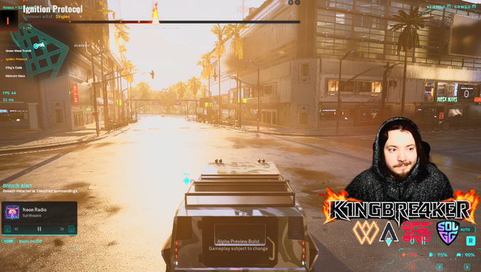 A first-person video game screenshot from "Cyberpunk 2077" shows a sunlit street scene with an overlay including the text "Ignition Protocol," a minimap, and a streamer overlay featuring a man's face and the name "KINGBREAKER."