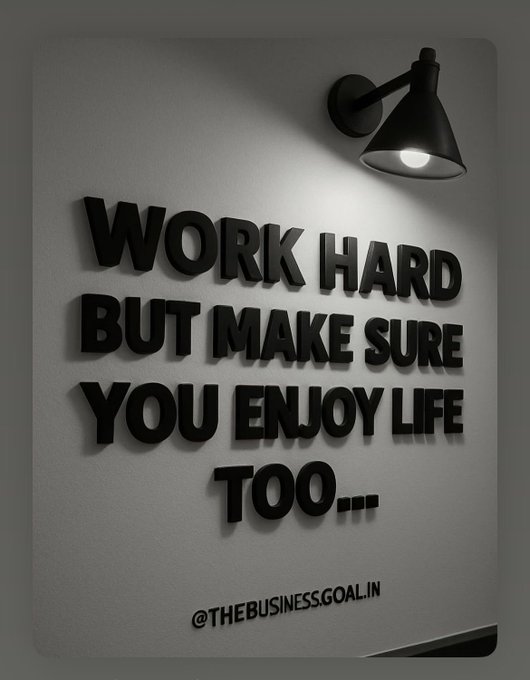 A motivational wall art piece featuring 3D black letters under a spotlight lamp reading 'WORK HARD BUT MAKE SURE YOU ENJOY LIFE TOO...' with the watermark '@THEBUSINESS.GOAL.IN'.