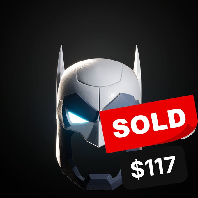 A 3D rendering of a metallic Batman-style cowl with glowing white eyes is displayed against a black background, overlaid with a red 'SOLD' banner and a black '$117' price tag.