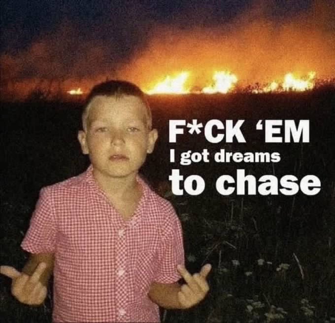 A popular internet meme featuring a young boy in a checkered shirt standing in a field at night with a large fire in the background, accompanied by the text 'F*CK 'EM I got dreams to chase'.