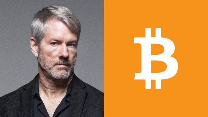 A split image featuring MicroStrategy co-founder Michael Saylor on the left, shown with gray hair, a beard, and wearing a dark patterned blazer, alongside the white Bitcoin logo on an orange background on the right. The image relates to the accompanying post about Strategy's (formerly MicroStrategy) notable 5-week pause in Bitcoin acquisitions under Saylor's leadership.