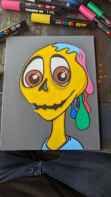 A creative painting of a melting, colorful skull-like character on a gray canvas, with Uni POSCA paint markers scattered above it on a dark surface.