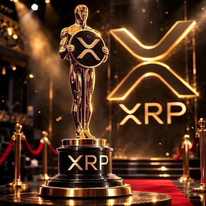 The image features a golden trophy, likely an Oscar award, placed on a red carpet with the text "XRP" written on it. The trophy is surrounded by a red rope barrier, which suggests that this event takes place at a movie or theater. In the background, there are two large posters of XRP logos, indicating its prominence in the industry. The image also contains some text about a payment option for XRP, suggesting that the event may be related to cryptocurrency or digital payments.