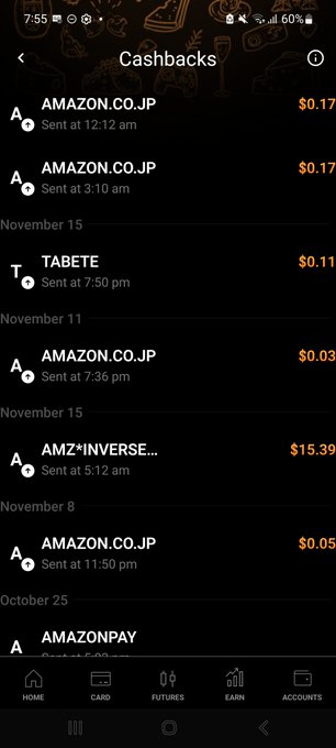 A screenshot of a mobile app's 'Cashbacks' page displaying a list of transactions, primarily from 'AMAZON.CO.JP' with small dollar amounts, along with entries for 'TABETE' and 'AMZ*INVERSE...'. The app has a dark theme and navigation tabs at the bottom for Home, Card, Futures, Earn, and Accounts.