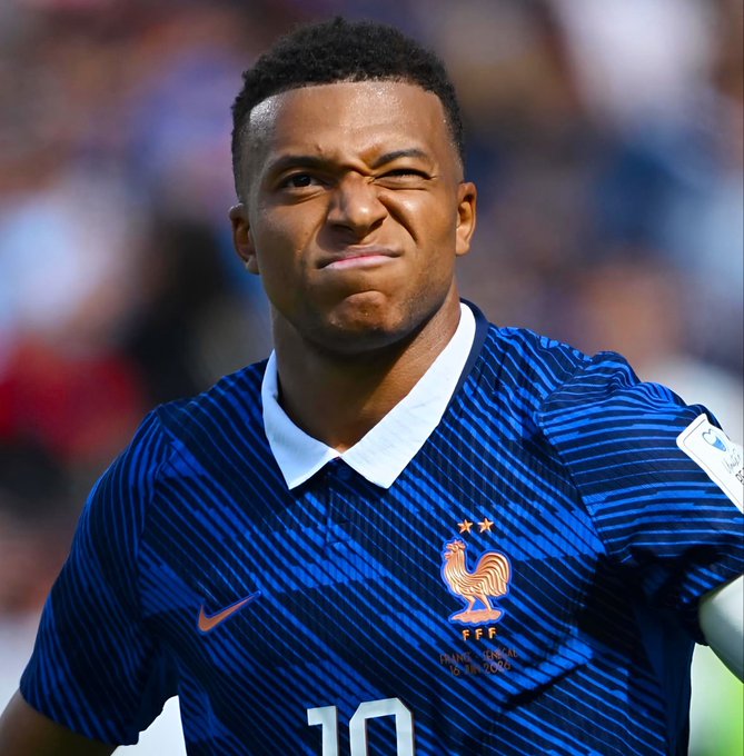 A young soccer player wearing a blue France national team jersey (number 10) grimaces during a match, appearing frustrated—fittingly illustrating the Polymarket bet against Kylian Mbappé scoring against Morocco, with the text "FRANCE - NORMAL 15 JUIN 2019" visible on his kit.