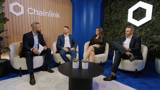 Four people in business attire sit in cream-colored chairs at a panel discussion in front of a 'Chainlink' branded backdrop.