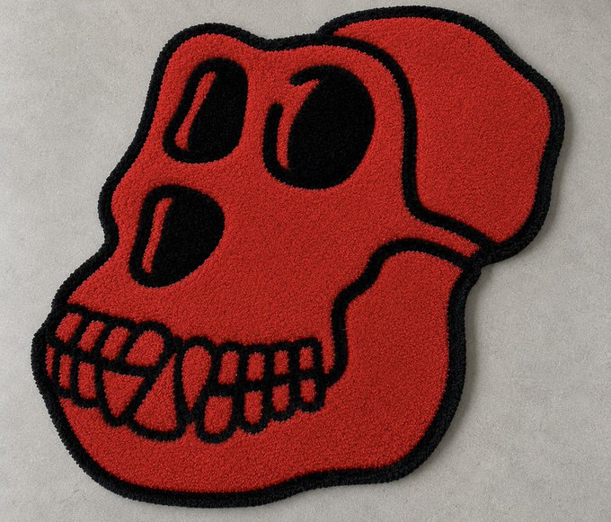 A red and black tufted rug shaped like a skull rests on a light gray surface.