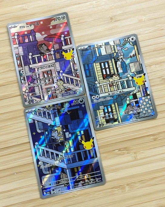 Three Japanese Pokémon cards featuring Meowth (ニャース) artwork are displayed on a wooden surface, showcasing colorful illustrations of the character in urban settings with HP values of 70 and 60 visible, representing the completed "Meowth set" mentioned in the post.
