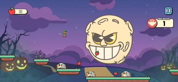 A 2D video game screenshot displays a Halloween-themed level where a small character jumps among platforms holding skulls, jack-o'-lanterns, and apples, facing a giant bald enemy head, with a UI showing '23' apples and '1 FREE REVIVE!'.