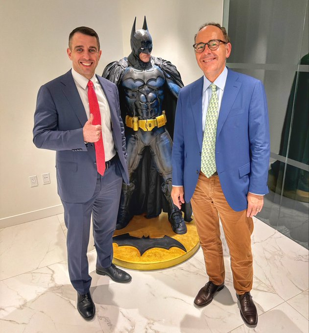 The image features two men standing next to a Batman statue. One man is wearing a suit and tie while the other has a blue jacket and brown pants. They are both smiling, seemingly posing for a photo with the Batman statue as their backdrop. The caption of the image reads " Later today I am releasing a conversation with @JanvanEck3 on private credit, gold, bitcoin and the rise of ETFs".