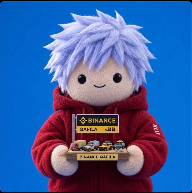 A plush character with pale blue hair and a red hoodie holds a miniature "BINANCE QAFILA" sign and a toy display labeled "BINANCE QAFILA."