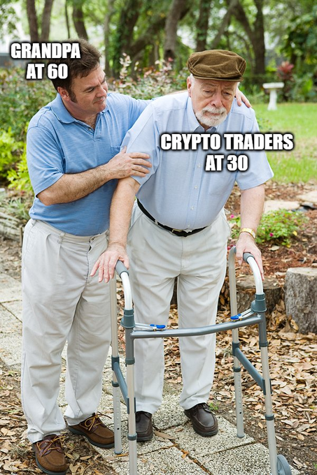 A meme showing a younger man in a blue shirt supporting an elderly man with a walker, labeled "GRANDPA AT 60" and "CRYPTO TRADERS AT 30," humorously suggesting crypto trading ages you prematurely. The image illustrates how crypto traders are often exhausted, worn out, and broken down at a young age.