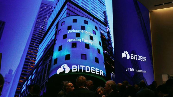 A photograph of a Bitdeer (BTDR) display at Nasdaq celebrating the company's listing, with a crowd gathered below the large screens reading "Welcome to the Nasdaq Family!"