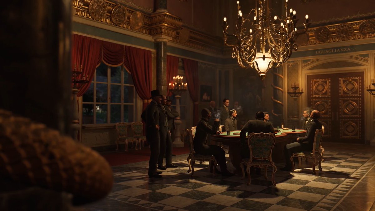 Men in dark suits gather around a green card table beneath a grand chandelier in an opulent room, with the inscription "UGUAGLIANZA" visible above the doorway, evoking a clandestine high-stakes poker game where power and peril intertwine.