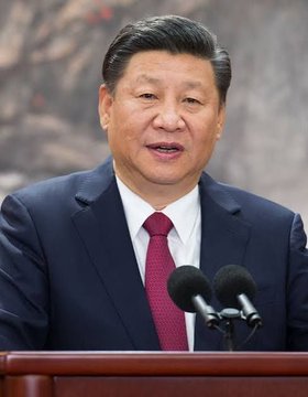 The image shows Xi Jinping, the leader of China, whose government is implementing a national blockchain network as part of its economic strategy.