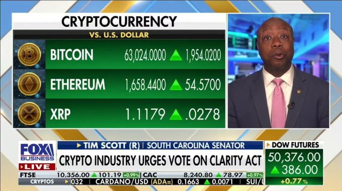 The image shows a news segment with a man wearing a suit talking about Bitcoin and Cryptocurrency. The news anchor is reporting that there are new rules coming into effect for cryptocurrency exchanges, which could impact the industry. This information is displayed on a screen behind the man in the suit, along with other financial data such as stock prices and market trends.