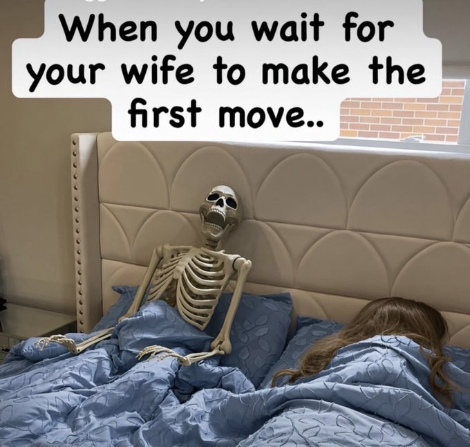 A skeleton propped up in bed waits beside his sleeping wife, with text reading "When you wait for your wife to make the first move.." The meme humorously illustrates extreme patience (waiting until death), likely used to attract engagement emoji/gif replies for the $100 USDT giveaway.
