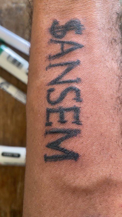 A close-up image shows a tattoo on a person's forearm that reads "MESSIAH" in bold, vertical black lettering. The caption and the post's reference to a "Black Bull" likely allude to a trading or investment context, where "Messiah" and the bullish "Black Bull" symbolize confidence in reaching a market peak.