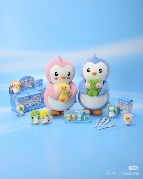 A Pudgy Penguins x LINE FRIENDS collaboration display featuring large pink and blue penguin plush toys holding smaller chicks, surrounded by blind box figures, figurines, and merchandise boxes against a soft blue background, promoting the October 1st launch in Korea and China.
