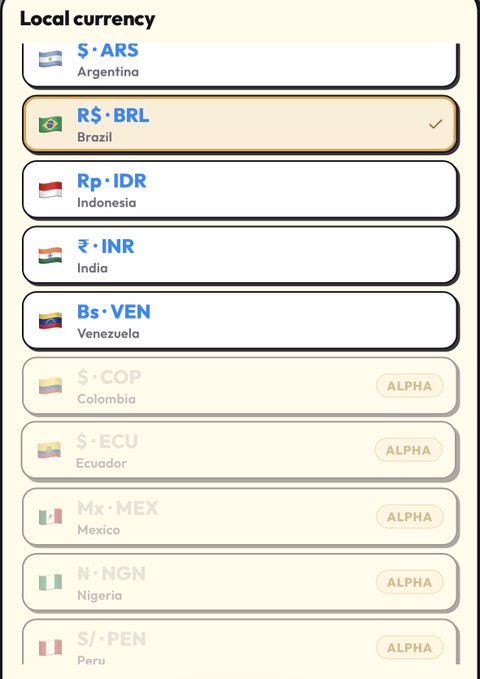 A mobile app interface titled 'Local currency' lists various countries and their currency codes, with Brazil's R$ · BRL selected, while currencies for Colombia, Ecuador, Mexico, Nigeria, and Peru appear grayed out with 'ALPHA' tags.