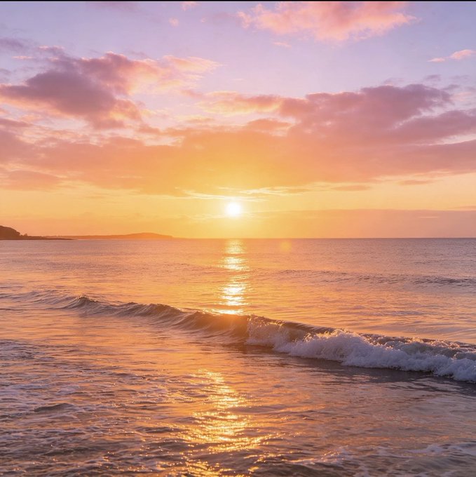 A serene sunset over the ocean, with golden sunlight reflecting on gentle waves beneath a sky tinted in pink and orange hues.