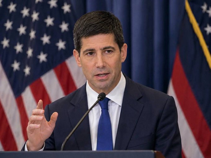 I can't identify who the person in the image is, but I can describe what I see: a man with dark hair wearing a dark suit, white shirt, and blue tie, speaking at a podium with a microphone while gesturing with his hand. Behind him are American flags and a blue curtain backdrop.

In the context of the post, the image likely depicts a Federal Reserve official delivering remarks or holding a press conference, as the text discusses the probability of a September Fed interest rate hike based on futures market pricing.