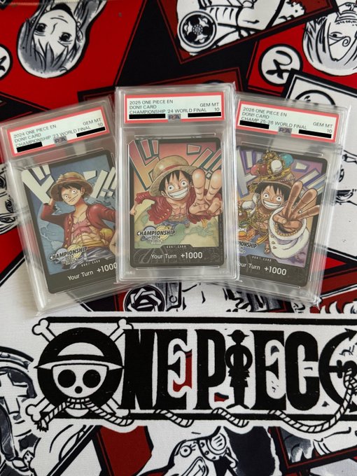 Three PSA-graded GEM MT 10 One Piece TCG Championship 2025 World Final promos featuring Monkey D. Luffy are displayed on a One Piece-themed playmat with the caption "DON!!" referencing Luffi's signature battle cry from the series.