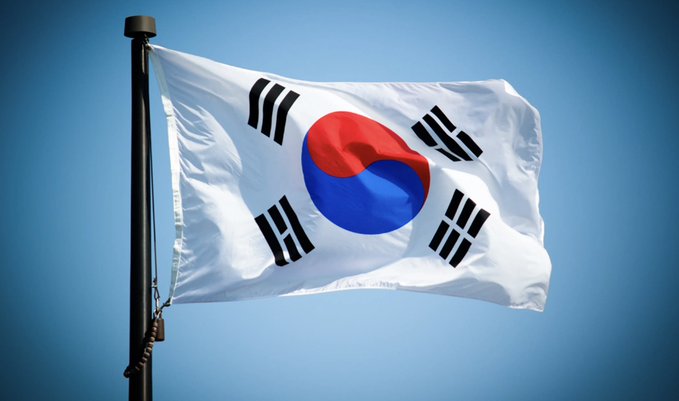 The South Korean flag waves against a clear blue sky, symbolizing the country at the center of a new policy development: a July 29 report by Hashed Open Research and the Solana Policy Institute recommending interim stablecoin regulations ahead of the Digital Asset Basic Act.