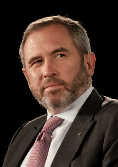 Ripple CEO Brad Garlinghouse, pictured in a formal suit and pink tie, appears on CNBC to criticize Michael Saylor's strategy for contributing to the crypto market slump, arguing that "financial engineering doesn't drive long-term value. Utility does."