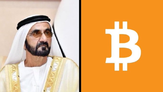 The image features a man wearing traditional Arab clothing, possibly a white robe or a kufi cap, standing next to an orange square with the letter "B" written on it. The man appears to be posing for the photo while looking off into the distance. The background of the image is blurred and does not provide any additional context about the content of the post.
