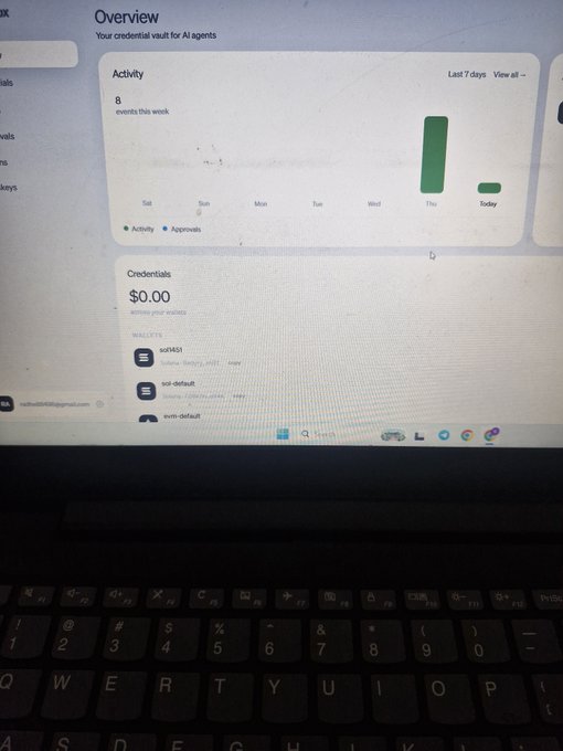 A photograph of a laptop screen displaying an 'Overview' dashboard for AI agent credentials, showing '8 events this week' and a balance of '$0.00'.