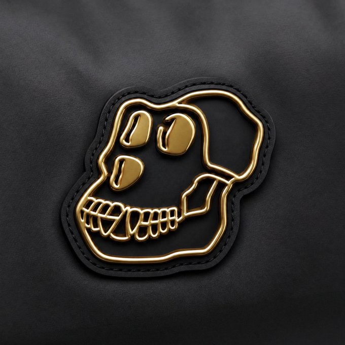 A 3D-rendered golden skull with stitched-mouth design mounted on a black leather patch, set against a dark textured background.